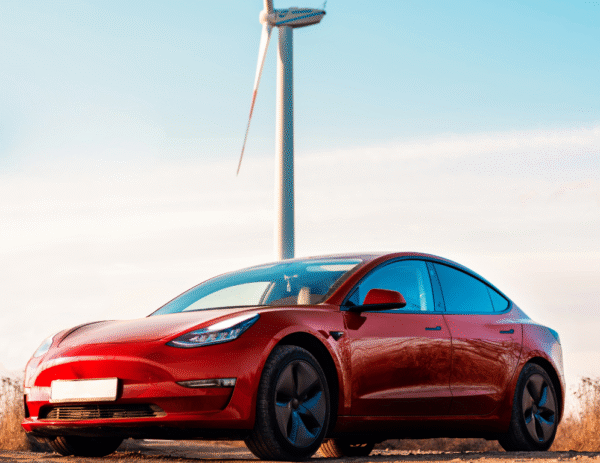 Tesla parked next to wind turbine