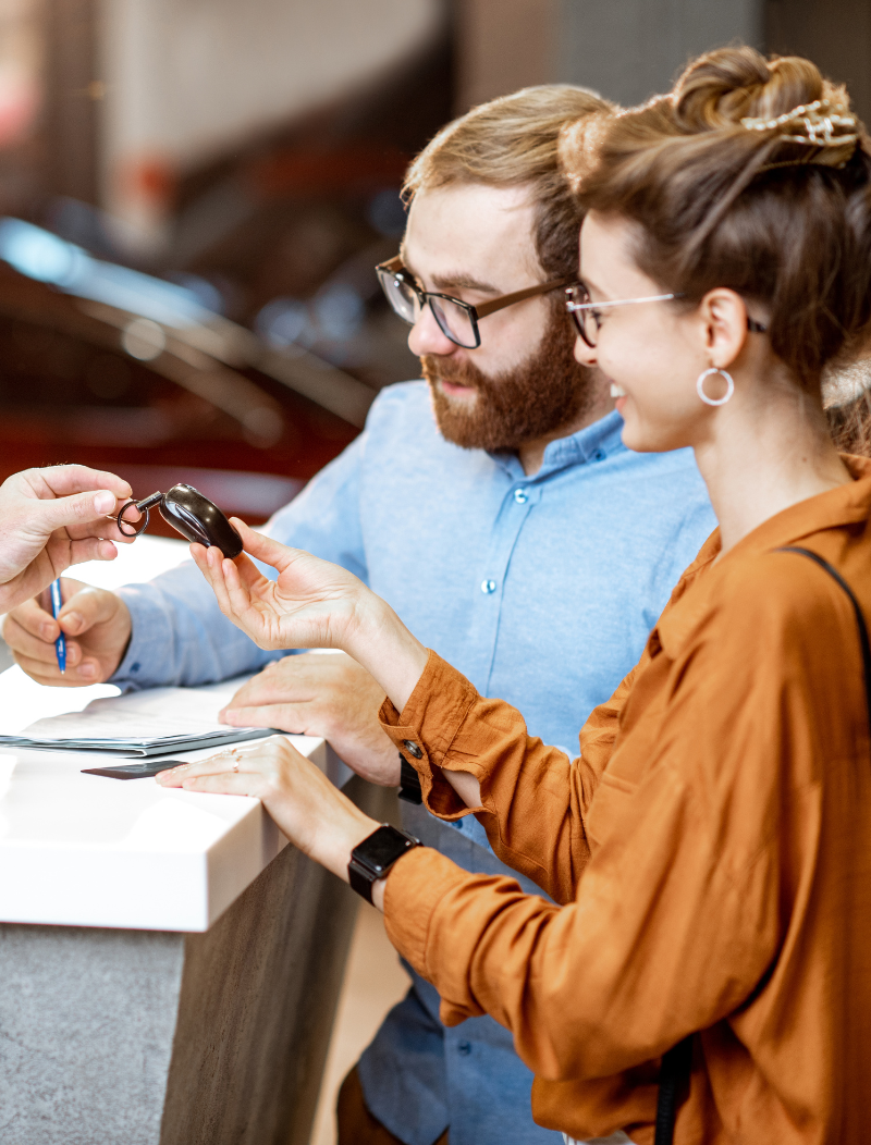 Man and woman signing car lease agreement