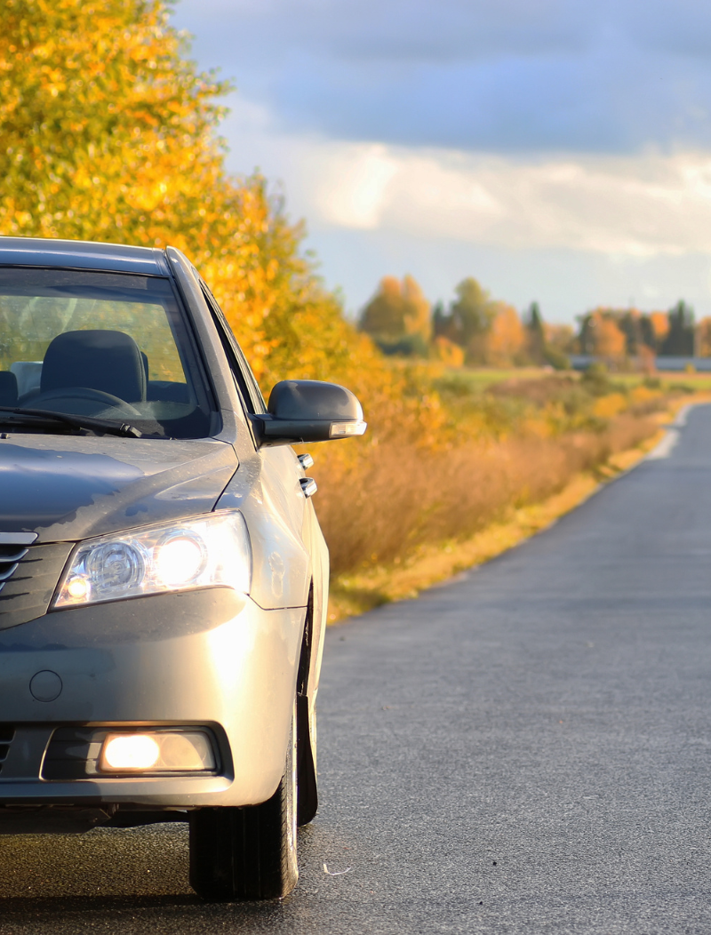Grey saloon car by the side of a country road