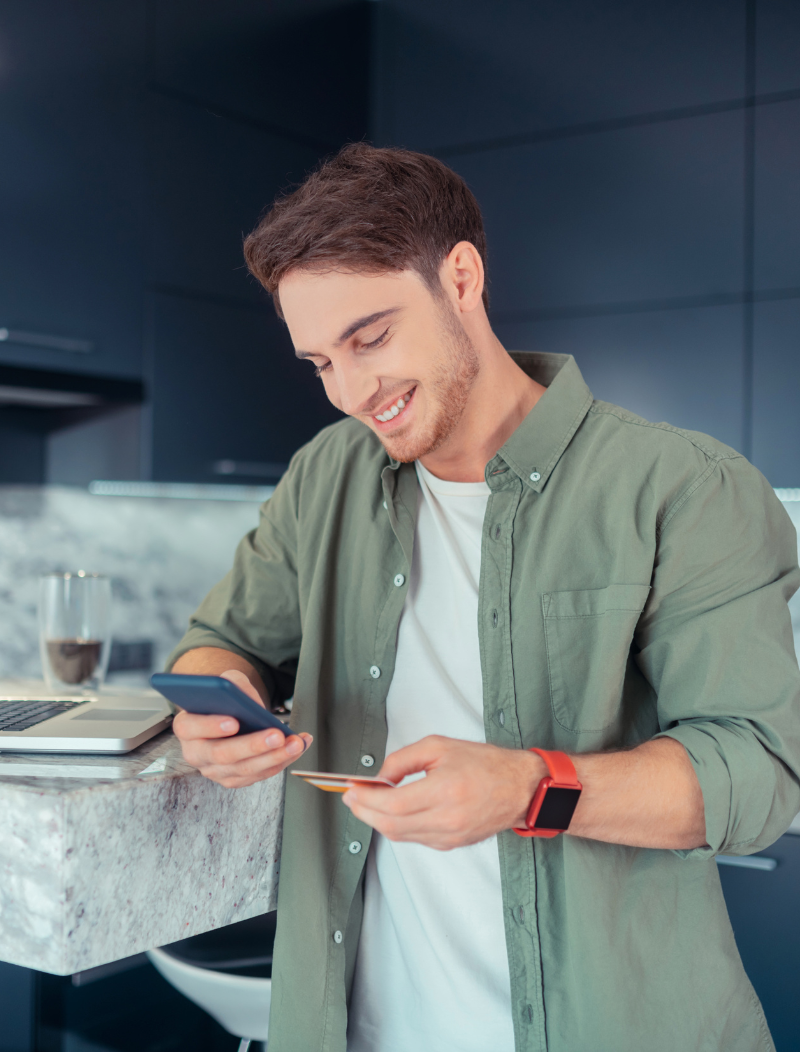 Well dressed young man making e-commerce transaction on mobile phone