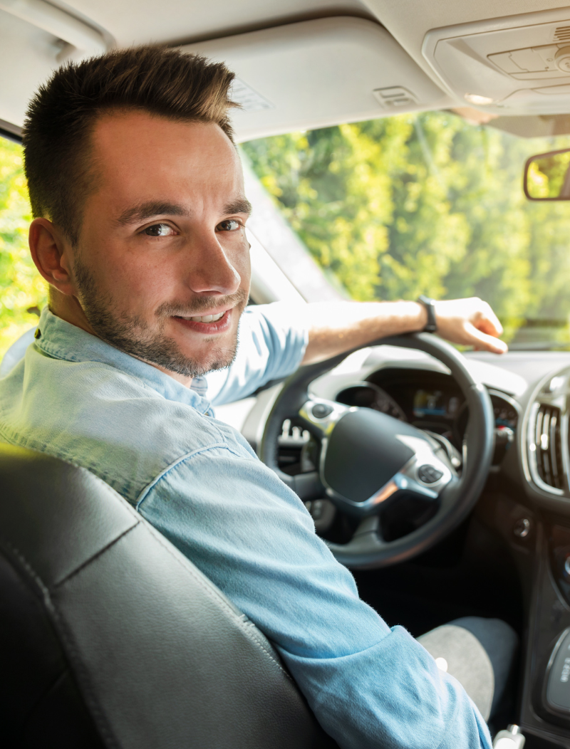 Satisfied man behind the wheel of a car