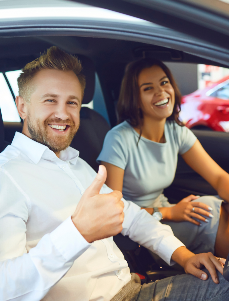 Man giving thumbs up with happy with in new leased car