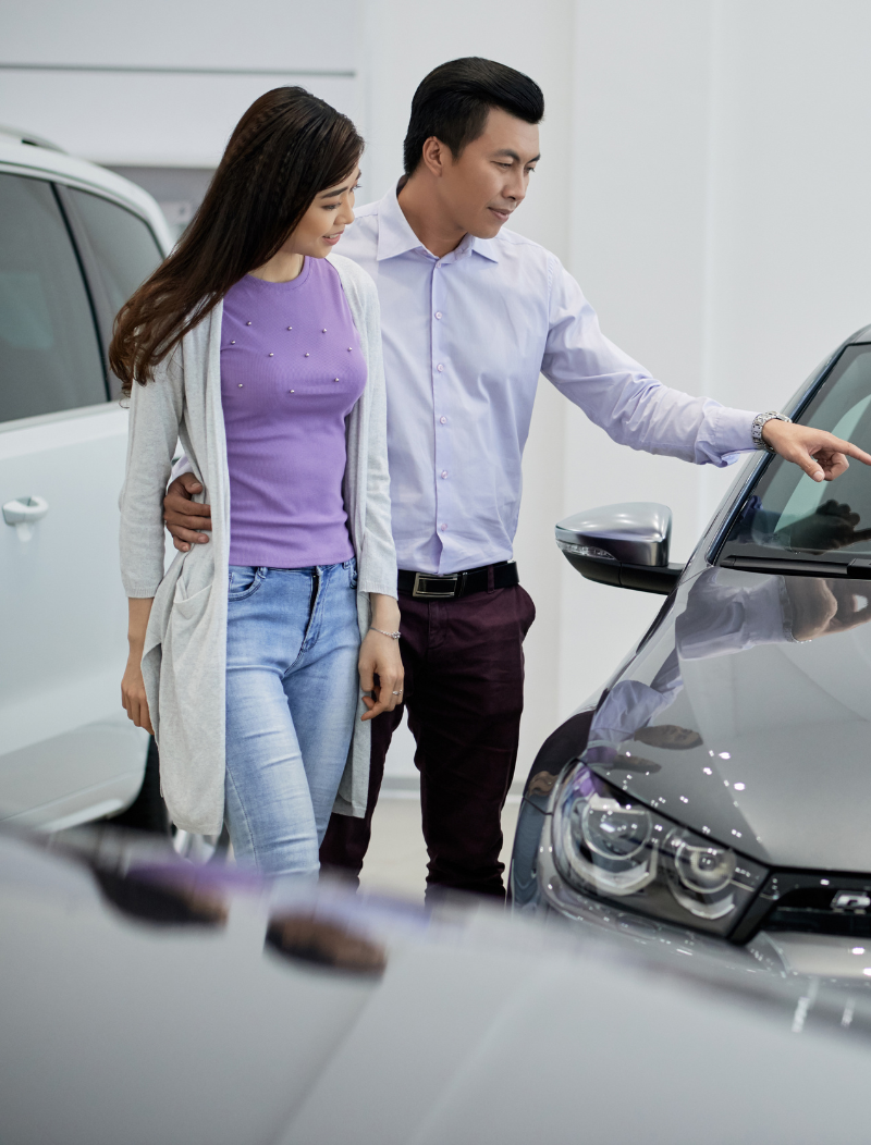 Asian couple examining cars